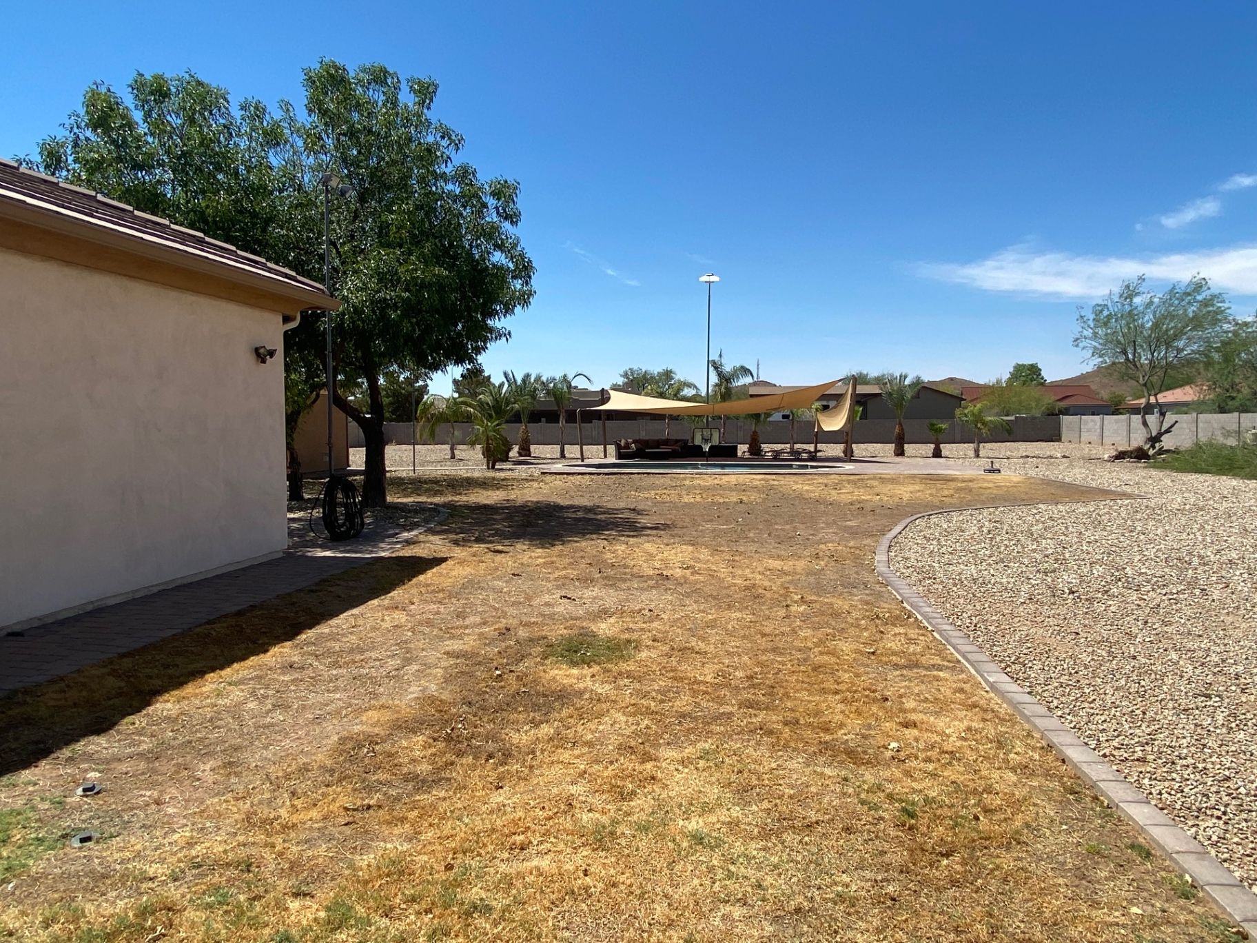 Aurora Estate — side yard before with bare gravel border