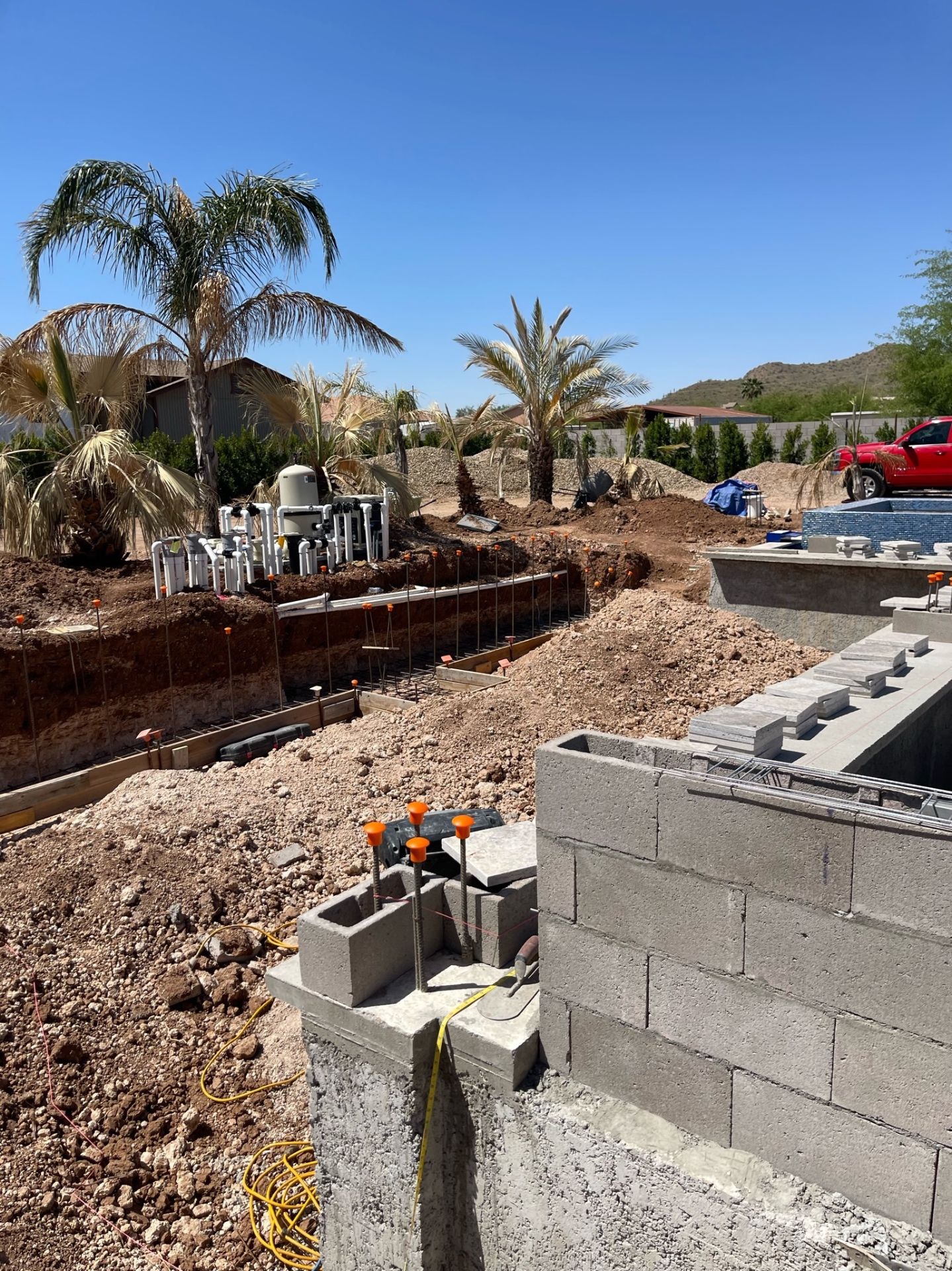 Aurora Estate — broad mid-build view showing retaining walls, pool shells, equipment area, and open grade before final hardscape