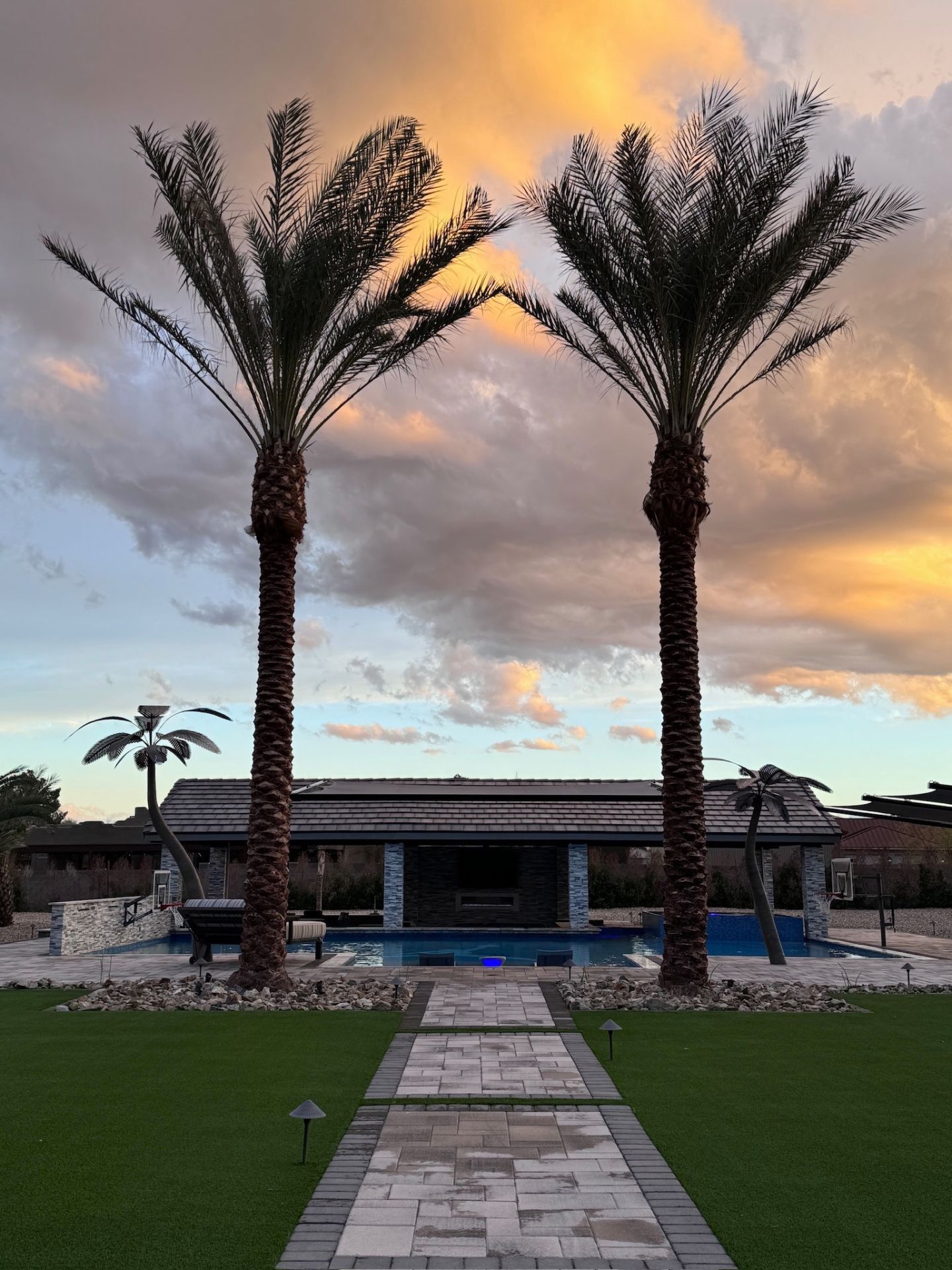 Aurora Estate — twin date palms framing the pavilion at golden hour